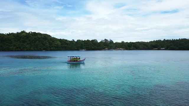 Traditional Indonesian Ache boat with snorklers cruising around iboih beach in Sabang Indonesia