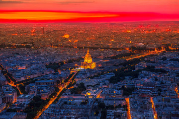 Aerial view of national residence of the Invalids palace on red sunset with night street light from panoramic terrace of Tour Montparnasse. Paris urban skyline cityscape. European capital of France.