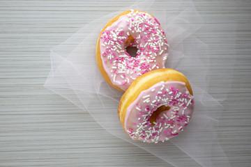 Pink donuts served for breakfast with piping hot coffee.
