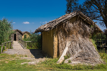Fototapeta na wymiar Huts at the reconstructed site of a prehistoric settlement at the Kastoria Lake in Dispilio, Greece 