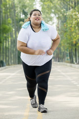Obese woman running on the road