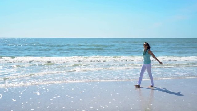 4K Beautiful senior woman walking on the beach in Sarasota Florida