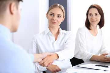 Fototapeta premium Business handshake by blonde woman and her partner at meeting. Concept of success and agreement