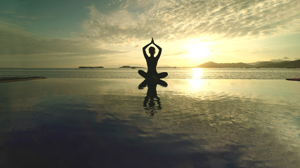 Unknown woman meditating on the beach