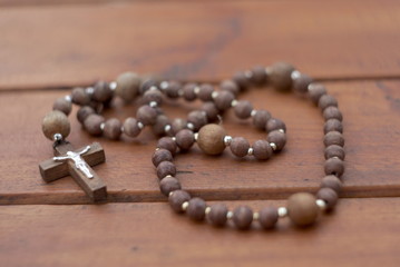Christian rosary on wooden table 