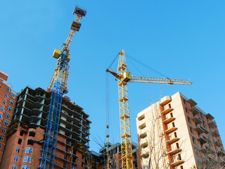 Fototapeta na wymiar Construction site background. Two industrial cranes near buildings.Commercial construction project.
