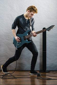Young man playing electric guitar