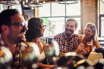 Amis heureux s& 39 amusant au bar - Jeunes branchés buvant de la bière et riant ensemble