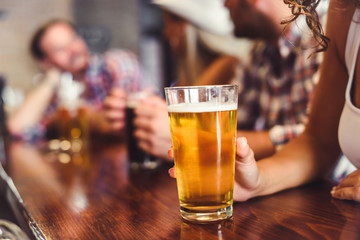 Happy friends having fun at bar - Young trendy people drinking beer and laughing together