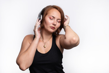 Woman touching wireless headphones with eyes closed and head position downwards