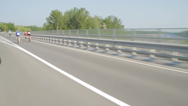 Cyclists Race Along Open Road In Summer. Contestants Compete In The Annual Ironman Race In Austria.