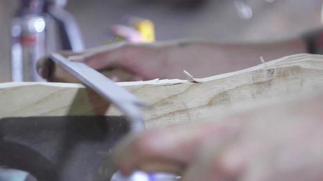 Shaving an axe handle in a workshop in slow motion