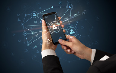 Female hand using smartphone to connect peoples all around the online surface
