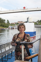 The Russian woman with the SLR camera costs onboard the motor ship floating down the river Tura in...