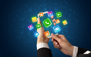 Female hand using smartphone with 3D shiny starlike application icons around
