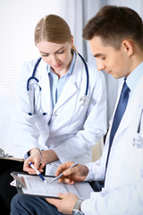 Doctors discussing medication records form or studying at medical conference. Healthcare, insurance...