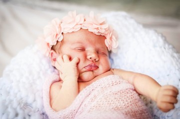 Cute Caucasian infant baby girl asleep and supporting her cheek with a hand. Baby holding cheek stock image.