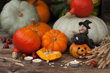 Pumpkin and witch on a wooden table, decoration for the holiday Halloween