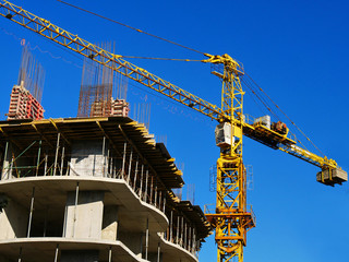Fototapeta premium Crane. Crane and building against blue sky. Construction site background.