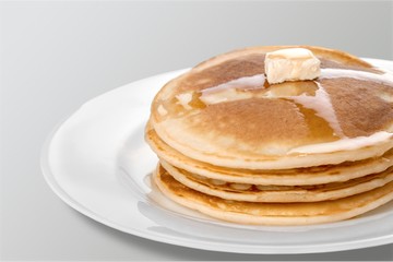 Stack of Small pancakes in syrup on background