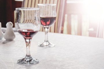 red wine in wine glasses on the table covered with white tablecloth