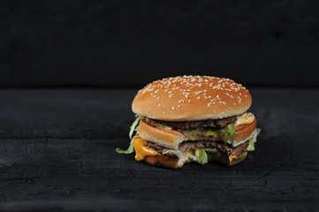 bitten burger on a dark rustic