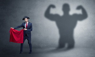 Businessman standing with red cloth on his hand and strong hero shadow on the background
