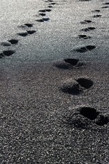 Human footprints in black sand