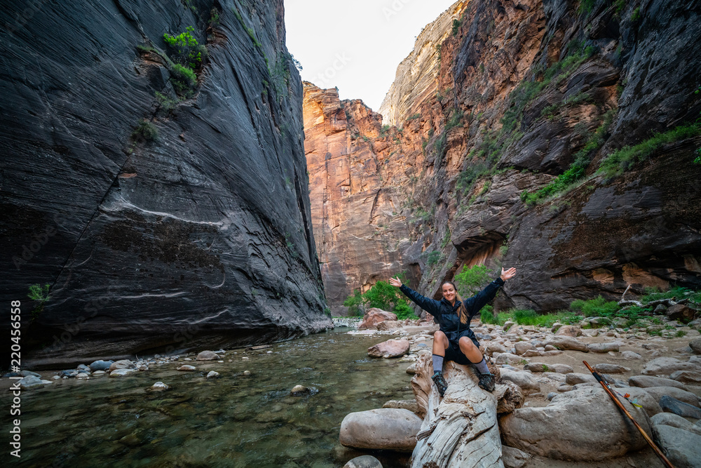 Wall mural young female hiking through the narrows, zion national park, utah - usa