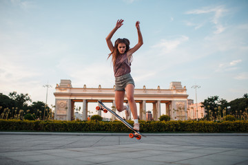 Young sporty woman riding on the longboard in the park © primipil