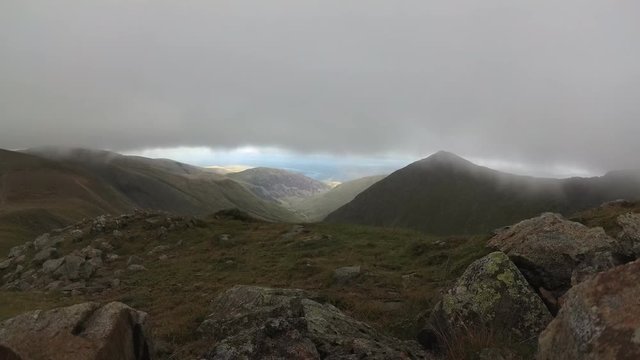 Superb mountain scenery with fast moving clouds. A breathtaking time lapse from the top of the Helvellyn peak in the Lake District with a scenery view over the valley and the English Ullswater lake. 