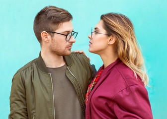 fashion couple standing posing near blue wall