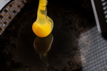 An egg frying in butter and oil in a carbon steel skillet
