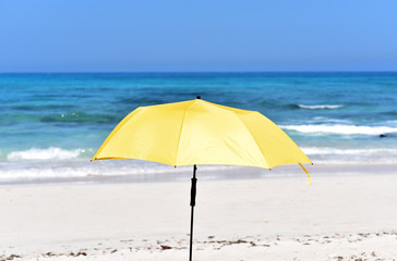 Obraz na płótnie Canvas Yellow sun umbrella in Corralejo Beach, Fuerteventura Island, Canary Islands, Spain