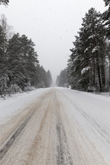 a dirty, broken snow-covered road