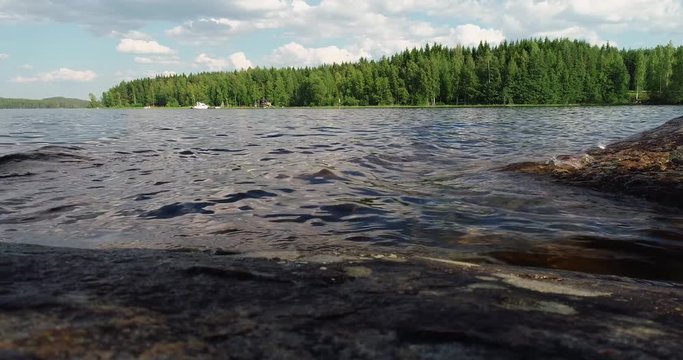 Waves by the lake seen from a cliff with forest on the other side of the lake, Puumala Finland