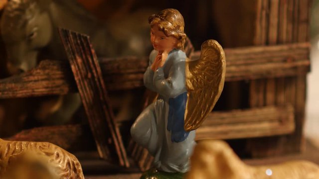A figurine of an angel looking at baby jesus from a vintage old European Christmas nativity or manger scene (creche).