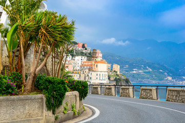 Fototapeta na wymiar Amalfi, Italy - View of the Amalfi coast town, palm trees and road