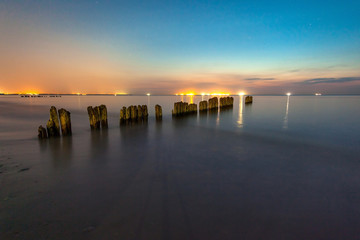 smooth sea surface and breakwaters at twilight under the stars for long exposure