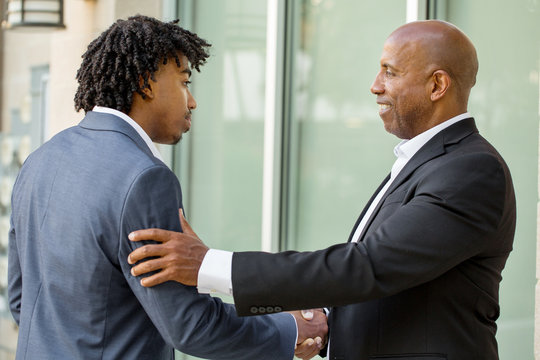 Mature African American casually dressed businessman shaking hands.