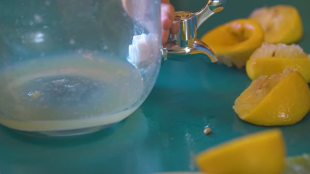 Lemon Juice Being Squeezed into a Jar to Make Lemonade