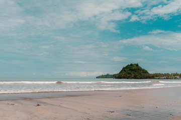 Obraz premium The Lone Island Across the Beach