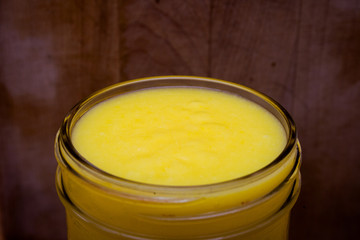 A close-up of lime curd in a glass jar.