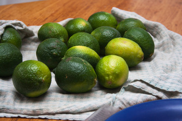 Limes on cotton cloth on a wooden table