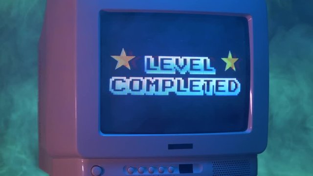 LEVEL COMPLETED title on a tube TV Vintage 80's 90's arcade.Zooming out with fog giving a retro look at the scene.