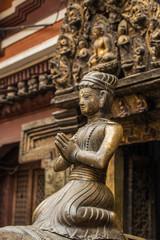 Fototapeta na wymiar The ancient bronze statue sitting in front of Golden Temple (Kwa Bahal) in Patan, Nepal. 