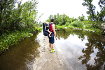 The daddy carries the child during a flood in the jungle.