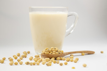 Glass of soy bean milk  soy bean on wooden spoon  on white background
