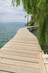 Obraz premium Sentiero di tavole di legno lungo il lago