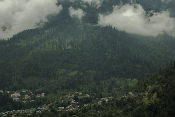 Fototapeta na wymiar heavy cloud on the green mountain and village